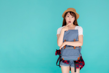 Beautiful portrait young asian woman wearing hat smiling and thinking idea with holding backpack to travel summer trip in holiday in vacation isolated blue background, tourist asia girl is having bag.