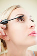 © DragonImages - Close-up image of pretty young woman applying second coat of black mascara on her eyelashes