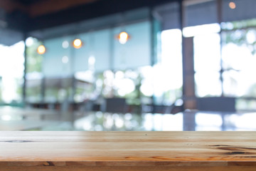 Wall Mural - wooden table with blurred of coffee's shop for abstract background