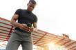 © alfa27 - serious african american sportsman sending sms, message while standing in the park. low angle view. copy space.