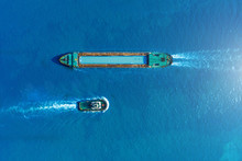 Cargo Ship Barge And Tugboat Sail To Meet Each Other In The Seaport Of The Port, Aerial View.