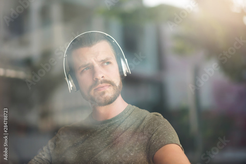 Cuadros en Lienzo Portrait of bearded man listening to music with headphones.
