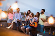 © NDABCREATIVITY - Group of happy friends having party on rooftop