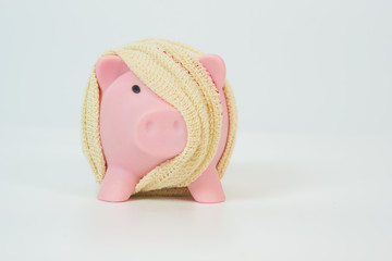 pink piggy bank with bandages on isolated background