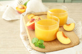 Fototapeta Kuchnia - Glasses of tasty peach juice on wooden board