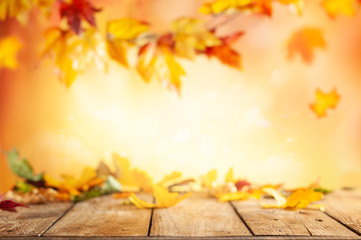 Wall Mural - wooden table and blurred autumn background. autumn concept with red-yellow leaves background.