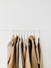 Wall Mural - A hanger of warm beautiful feminine beige sweaters or pullovers. Autumn, fall, winter, fashion concept. Empty space, mock up. minimal background.