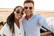 © Drobot Dean - Photo of attractive multiethnic couple wearing sunglasses taking selfie photo together while standing by car on beach