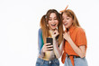 © Drobot Dean - Full length portrait of two teenage girls wearing casual clothes having fun and using smartphone together