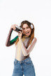 © Drobot Dean - Portrait of beautiful young woman wearing headphones smiling and holding retro camera