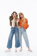 © Drobot Dean - Full length portrait of two young girls smiling while holding basketball and retro camera