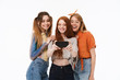 © Drobot Dean - Portrait of three charming girls wearing casual clothes smiling and taking selfie photo on smartphone together