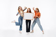 © Drobot Dean - Portrait of three joyous girls wearing casual clothes smiling and holding copyspace frame together