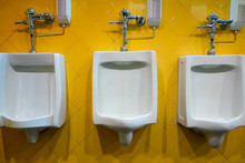 Male Urinals In Men Toilet With Yellow Tiles Wall