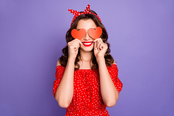 Wall Mural - Pretty lady in playful mood hiding eyes with little heart figure cards wear red dress isolated purple background