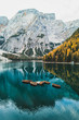 Autumn landscape of Lago di Braies Lake in italian Dolomites mountains in northern Italy. Drone aerial photo with Wooden boats and beautiful reflection in calm water at sunrise. Pragser Wildsee