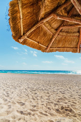 Wall Mural - View on beach under thatched sun umbrella