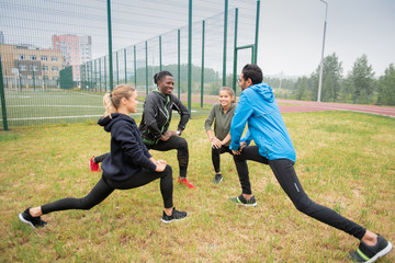 Canvas Print - Group of young multicultural friendly people doing stretching exercise for legs