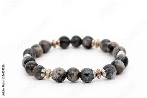 Fotomural Bracelet made of gray natural larvikite stone on a white background