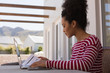 © WavebreakMediaMicro - Woman looking at documents while using laptop at home