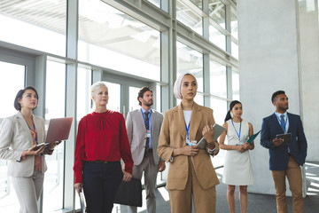 Wall Mural - Business people looking away while standing in office building