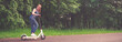© shintartanya - Young girl teenager millennial on a scooter rides in a city park on a summer day, lifestyle sports