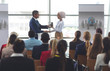 © WavebreakMediaMicro - Businesswoman receiving award from businessman in a business seminar