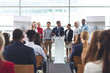 © wavebreak3 - Businessman standing at podium with colleagues and speaks in a business seminar