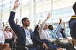 Business people raising hands in business seminar