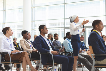 Businesswoman asking question during seminar