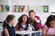 © Halfpoint - A teacher walking among small school children on the lesson, explaining.