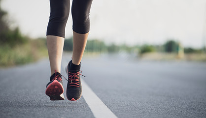 Wall Mural - Young woman runner running on city bridge road. Young fitness woman runner athlete running on the road in the morning