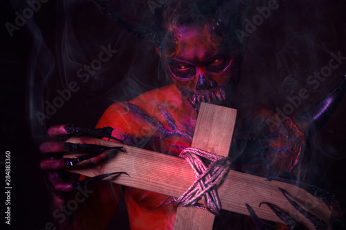 Cuadros en Lienzo Bad devil or monster bite the holy cross on halloween day