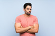 © luismolinero - Handsome young man in pink shirt over isolated blue background making doubts gesture while lifting the shoulders