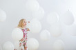 Leinwandbild Motiv little girl with white balloons indoor