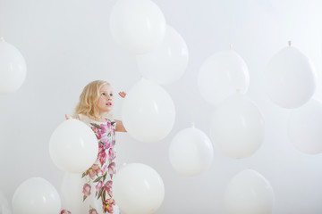 little girl with white balloons indoor