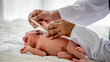© narong - Soft blur image of doctor hands use thermometer measure newborn baby temperature in the process of check up or treatment the baby.