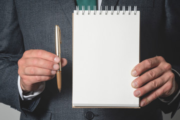 Wall Mural - Business to do list mockup. Business plan. Businessman holding a blank page notepad and a pen.