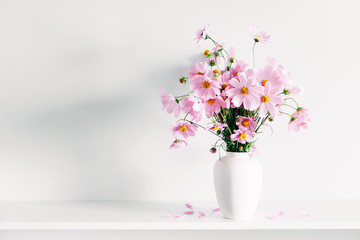 Wall Mural - fresh summer bouquet of pink cosmos flowers in white vase on white wood shelf on white wall backgrou