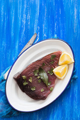 Wall Mural - raw tuna with lemon and bay leaf on ceramic background