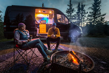 A couple by a fire in Teklanika Campground, Denali National Park, Alaska, USA