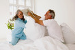 © Westend61 - Mature couple having pillow fight on bed