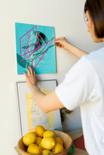 Woman Sticking Digital Drawings Onto A Wall