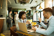 © bugarskipavle3 - Men are sitting at table in modern cafe. Talk about work