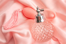 Femininity Personal Hygiene, Retro Fragrance, Makeup Table Items And Romantic Scent Concept Theme With Colorful Vintage Ornate Flask Of Scented Perfume On Pink Silk Or Satin Background