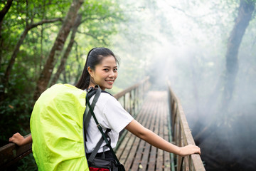 Wall Mural - Happy backpack woman in forest