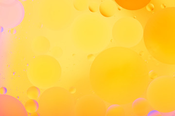 bright oily drops in water with colorful background, close-up