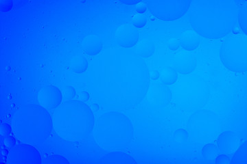 bright oily drops in water with colorful background, close-up