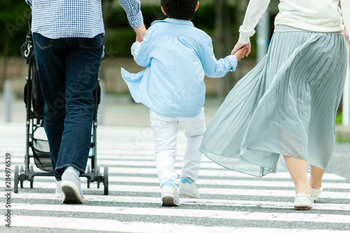 手を繋いで歩く家族3人の後姿 Stock Photo Adobe Stock