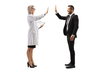 Poster - Young female doctor making high-five gesture with a businessman